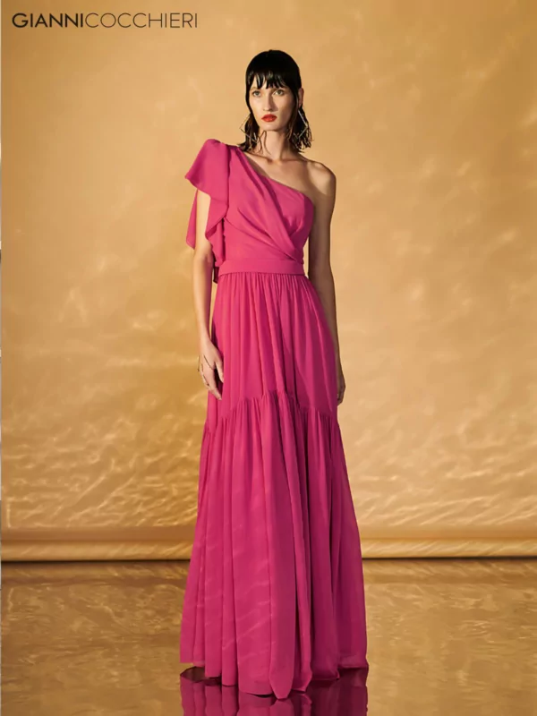 Vestido rosa de um ombro só, com drapeado indo do quadril a cintura. Saia plissada com várias camadas.