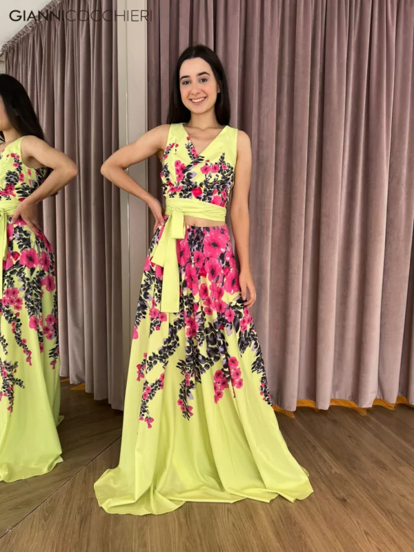 Vestido verde lima estampado com flores rosa, roxo e lilás. Abertura na barriga e laço na altura do abdômen. Decote V e saia fluida