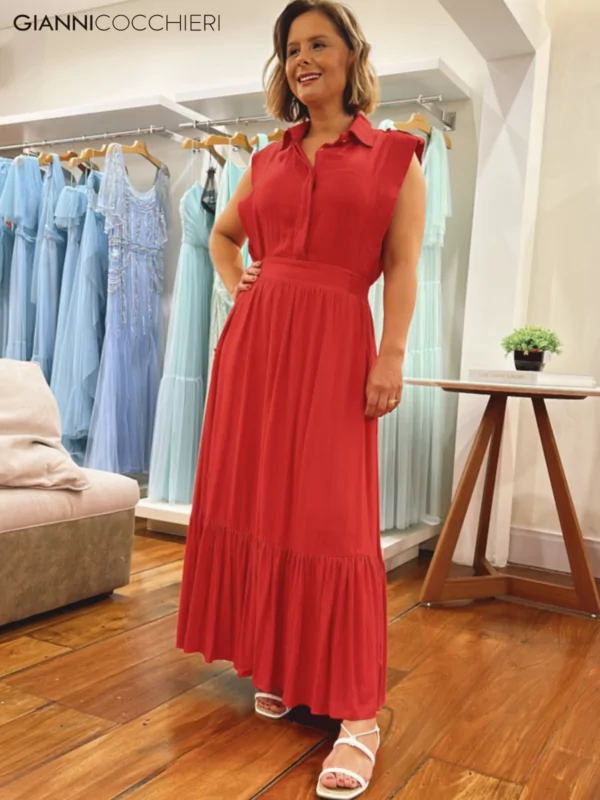 Vestido laranja plissado na saia. Parte superior estilo camisa social com abotoamento.