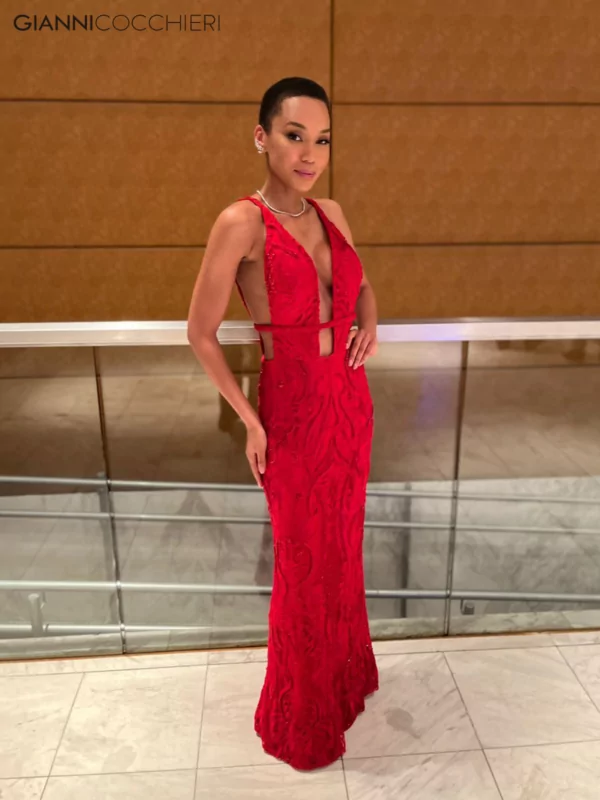 Vestido vermelho colado no corpo revestido com pedrarias. Possui um decote sexy até o umbigo