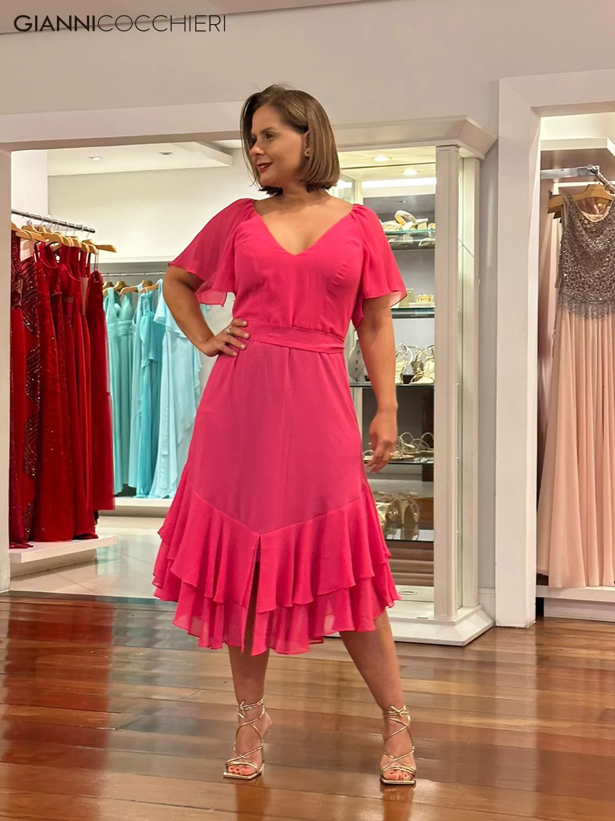 Vestido rosa com decote V, manga curta fluida e saia com babado.