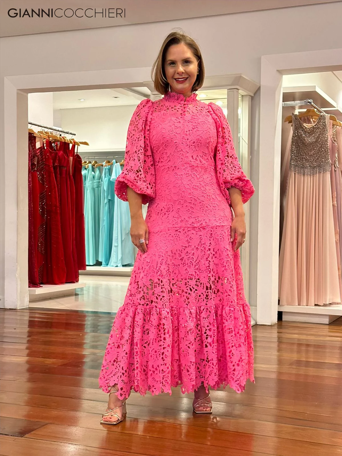 vestido com renda rosa, gola alta, manga bufante 3/4. Comprimento até o calcanhar.
