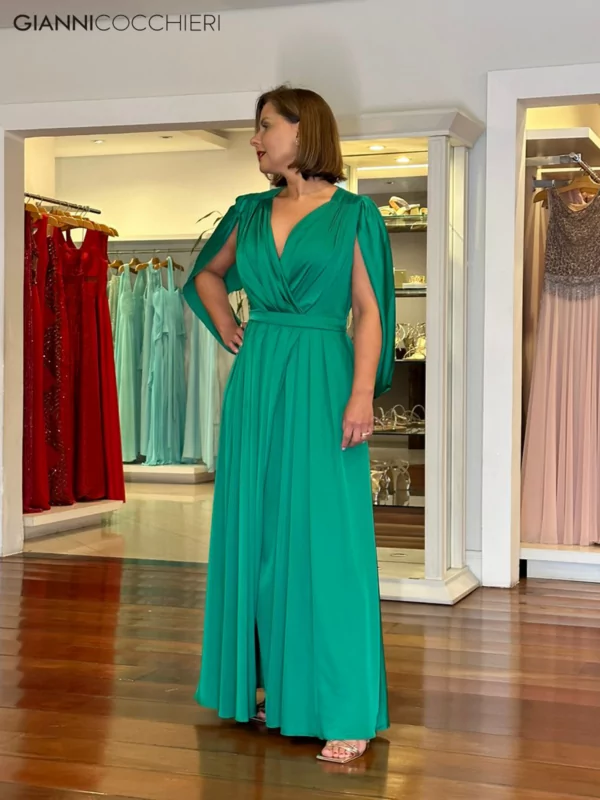 Vestido verde esmeralda com drapeado no busto e na saia. Manga indo do ombro para as costas.